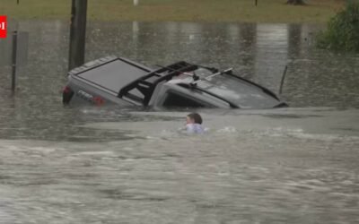 An Australian TV reporter was filming floods when he spotted a sinking four-wheel drive, swam out with a bystander and forced open a rear door to rescue the driver moments before the vehicle disappeared underwater